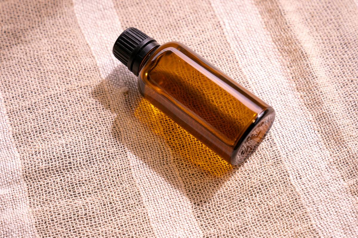 what is aromatherapy oil - glass bottles of lavender, tea tree, and eucalyptus essential oils arranged on wooden table